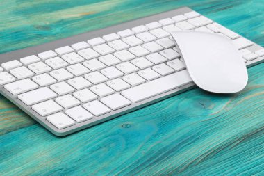 İş işyeri bilgisayar, kablosuz klavye ve fare üstünde eski mavi ahşap masa arka plan ile. Ofis Masası kopya alanı ile