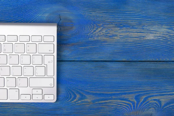 Lugar de trabajo de negocios con teclado inalámbrico sobre fondo de mesa de madera azul antiguo. Escritorio de oficina con espacio de copia — Foto de Stock