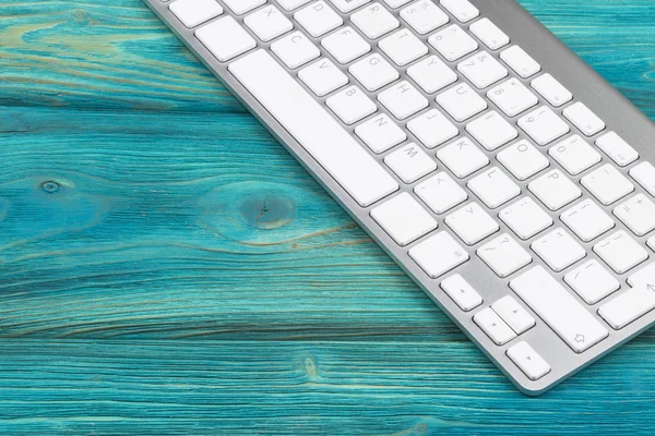 Lugar de trabajo de negocios con teclado inalámbrico sobre fondo de mesa de madera azul antiguo. Escritorio de oficina con espacio de copia — Foto de Stock