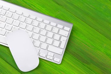 Bilgisayar, kablosuz klavye, anahtarları ve eski yeşil ahşap masa arka plan üzerinde fare ile iş yeri. Ofis Masası kopya alanı ile