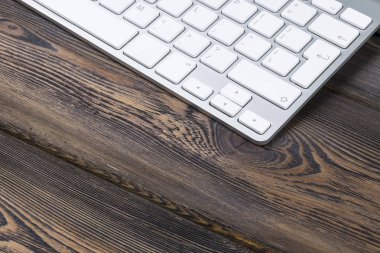 Kablosuz bilgisayar klavye ile bir iş çalışma alanı'nın görünümü kadar anahtarları eski karanlık doğal ahşap masa arka plan üzerine kapatın. Ofis Masası kopya alanı ile