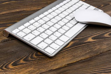 Kablosuz bilgisayar klavye tuşları ve fare üzerinde eski koyu ahşap masa arka plan ile bir iş çalışma alanı'nın görünümünü kapatın. Ofis Masası kopya alanı ile