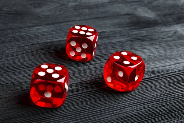 Conceito de risco - jogando dados em fundo de madeira preta. A jogar um jogo com dados. Rolos de dados de casino vermelho. Rolando o conceito de dados para risco de negócios, chance, boa sorte ou jogo — Fotografia de Stock