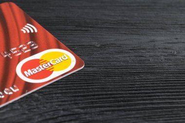 Sankt-Petersburg, Rusya, 09 Temmuz 2017: Mastercard kredi kartları logosuna office siyah Danışma Kurulu. siyah ahşap masa üzerinde bir Mastercard kredi kartı görünümünü kapatın. Sankt-Petersburg, Rusya, 09 Temmuz 2017 çekilmiş fotoğrafı