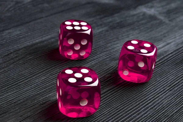 Conceito de risco - jogando dados em fundo de madeira preta. A jogar um jogo com dados. Rolos de dados de casino rosa. Rolando o conceito de dados para risco de negócios, chance, boa sorte ou jogo — Fotografia de Stock