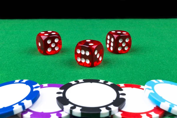 Ένα σύνολο στοίβα μαρκών πόκερ σε ένα πράσινο τραπέζι παιχνίδι με ζάρι ρολά. Μαύρο φόντο. έννοια του κινδύνου - παίζοντας πόκερ στο καζίνο. Θέμα παιχνίδι πόκερ. Κόκκινο Καζίνο ζάρια. — Φωτογραφία Αρχείου