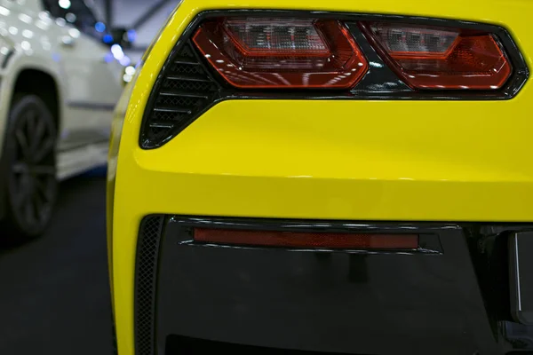 Задня червоний світло на сучасних жовтий автомобіль з відображенням. Крупним планом назад хвіст червоне світло автомобіля — стокове фото