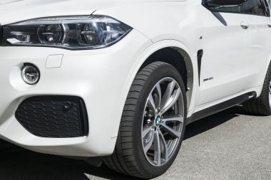  BMW X 5 M Perfomance. Lastik ve alaşım jant. Far. Beyaz modern lüks bir spor araba önden görünümü. Araba dış detaylar.