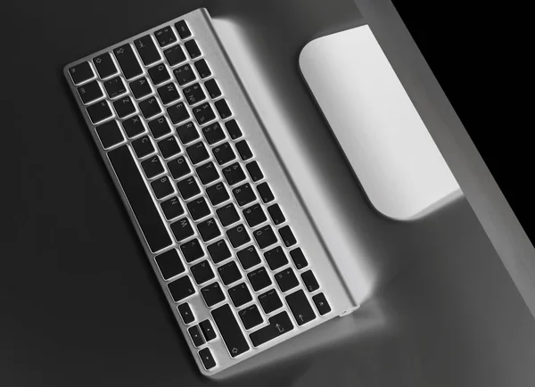 Obchodní pracoviště s počítači bezdrátové klávesnice a myši na starý černý stůl pozadí. Kancelářský stůl s kopií prostor — Stock fotografie