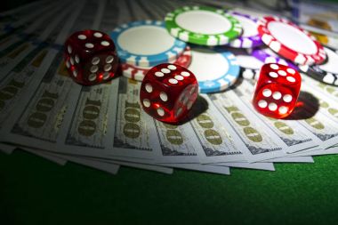 Zar ile Poker fiş yığını bir Doları faturalarında para alır. Casino poker masasında. Poker oyun kavramını. Zar bir oyun oynuyor. Casino zar. İş riski için kavram. şans iyi şanslar