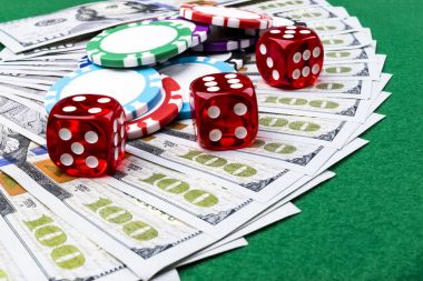 Zar ile Poker fiş yığını bir Doları faturalarında para alır. Casino poker masasında. Poker oyun kavramını. Zar bir oyun oynuyor. Casino zar. İş riski için kavram. şans iyi şanslar