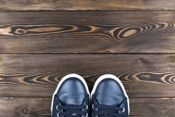 在木地板上的鞋的顶视图。鞋子在一个木制的背景上。在木地板上的运动鞋。体育、 健身、 鞋、 鞋类和对象的概念 — 图库照片