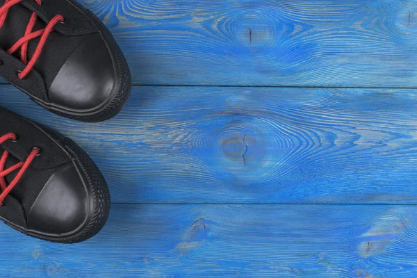 蓝色的木地板上的鞋的顶视图。鞋子在一个木制的背景上。在木地板上的运动鞋。体育、 健身、 鞋、 鞋类和对象的概念 — 图库照片