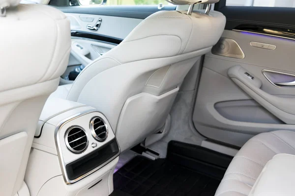 Interior de cuero blanco del coche moderno de lujo. Cuero cómodos asientos blancos y multimedia. decoración exclusiva de madera y metal. Detalles interiores del coche moderno . — Foto de Stock
