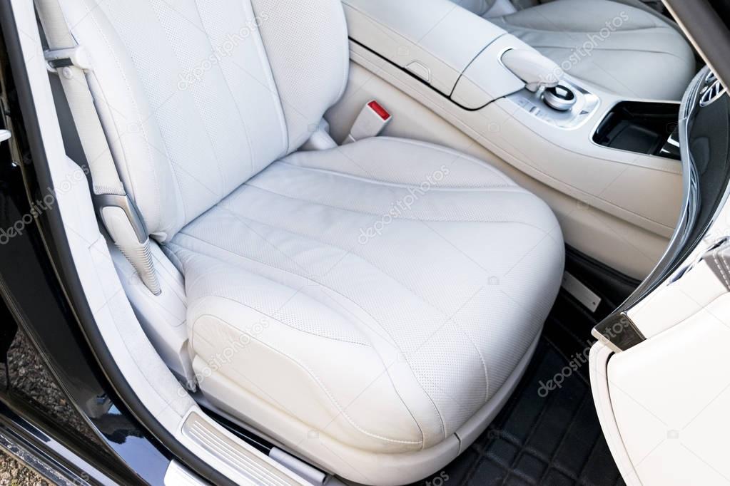White leather interior of the luxury modern car. Leather comfortable white seats and multimedia. Steering wheel and dashboard. automatic gear stick.