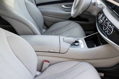 Beyaz deri iç lüks modern araba. Deri rahat beyaz koltuklar ve çoklu ortam. Direksiyon simidi ve gösterge tablosu. Otomatik vites. Araba iç detaylar
