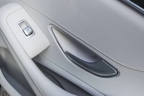 Detalles interiores de cuero blanco del coche de la manija de la puerta con controles de ventanas y ajustes. Controles de ventana de coche de coche moderno . — Foto de Stock