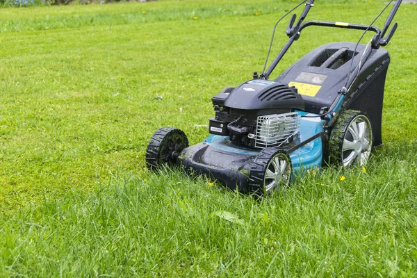 Sečení trávníků. Sekačka na trávu na zelené trávě. sekačka travní zařízení. sekání trávy blízko zahradník péče pracovní nástroj se pohled slunečný den — Stock fotografie