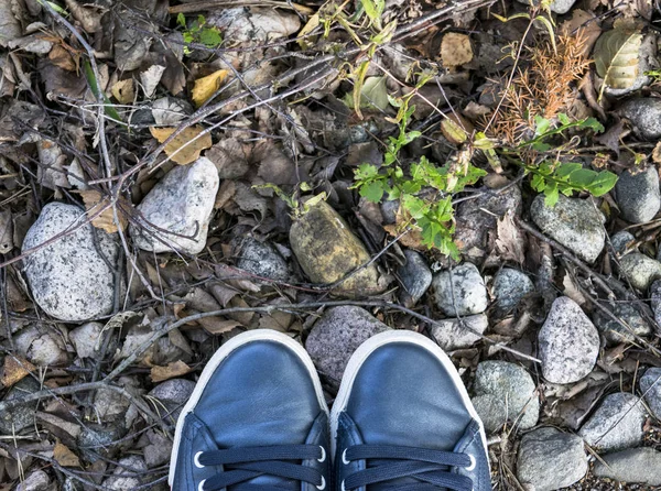 Pohled z boty na šedou kamennou zem. Boty na kamenné pozadí. Tenisky na kamenné podlaze. Sportovní fitness boty obuv a objekty koncept — Stock fotografie