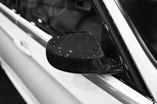 Carbone côté droit Miroir de voiture avec réflexion d'une voiture moderne. Détails extérieurs de voiture. Noir et blanc — Photo