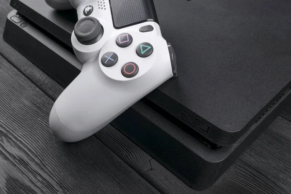 Sony Playstation 4 Slim 1tb Revision und Dualshock Game Controller. Spielkonsole mit Joystick. Heim-Videospielkonsole auf Holz-Hintergrund — Stockfoto