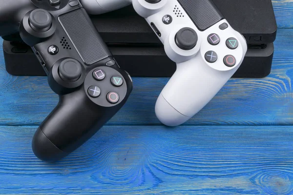 Sony Playstation 4 Slim 1 tb revize a 2 dualshock herní zařízení na pozadí dřevěný stůl. Domácí video herní konzola — Stock fotografie