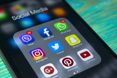 Mavi ahşap masa üstünde perde sosyal medya simgeleri ile iPhone 7 artı. Smartphone yaşam tarzı smartphone. Başlangıç sosyal medya uygulaması.
