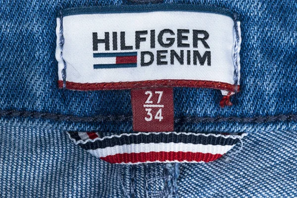 Primer plano de la etiqueta Tommy Hilfiger en jeans azules. Tommy Hilfiger es una marca de estilo de vida. Hilfiger Denim. Tommy Hilfiger detalle vaqueros azules — Foto de Stock