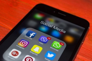 kırmızı ahşap masa üstünde perde sosyal medya simgeleri ile iPhone 7 artı. Smartphone yaşam tarzı smartphone. Başlangıç sosyal medya uygulaması.