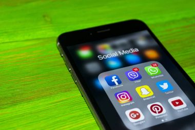 iPhone 7 artı yeşil ahşap masa üstünde perde üzerinde sosyal medya simgeleri ile. Smartphone yaşam tarzı smartphone. Başlangıç sosyal medya uygulaması.