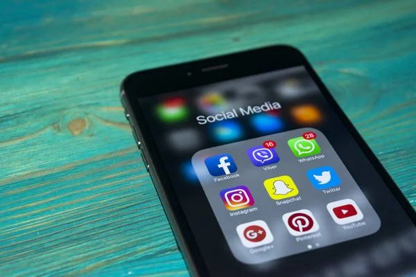  Mavi ahşap masa üstünde perde sosyal medya simgeleri ile iPhone 7 artı. Smartphone yaşam tarzı smartphone. Başlangıç sosyal medya uygulaması.