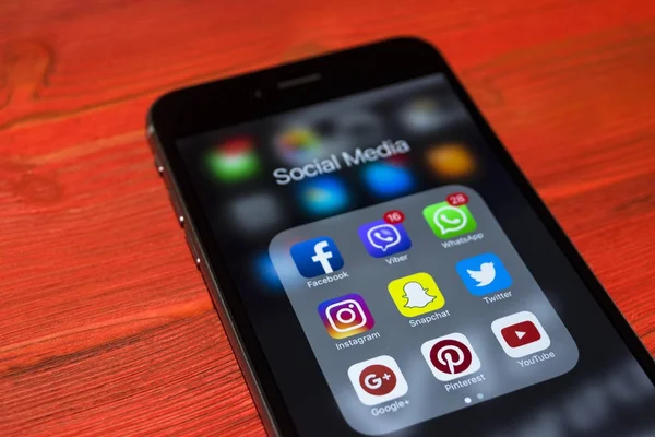kırmızı ahşap masa üstünde perde sosyal medya simgeleri ile iPhone 7 artı. Smartphone yaşam tarzı smartphone. Başlangıç sosyal medya uygulaması.