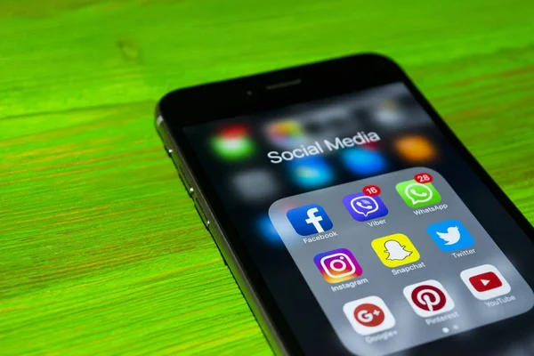 iPhone 7 artı yeşil ahşap masa üstünde perde üzerinde sosyal medya simgeleri ile. Smartphone yaşam tarzı smartphone. Başlangıç sosyal medya uygulaması.