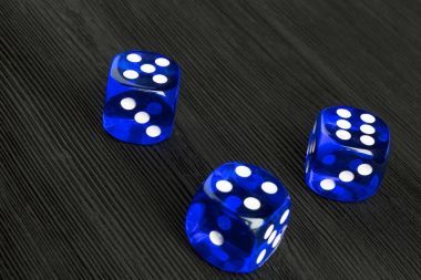 risk kavramı - zar siyah ahşap artalanda çalışır. Zar bir oyun oynuyor. Mavi casino zar. Çalışırken iş riski için zar kavramı, şans, iyi şanslar veya kumar