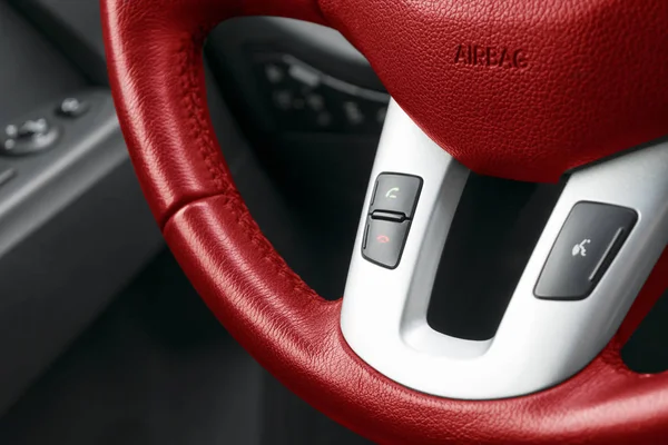 Handsfree och media kontrollknappar på röda ratten i svart läder, moderna bilens interiör — Stockfoto