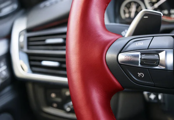 Cruise control-knoppen op de rode stuurwiel van een moderne auto, auto interieur details — Stockfoto