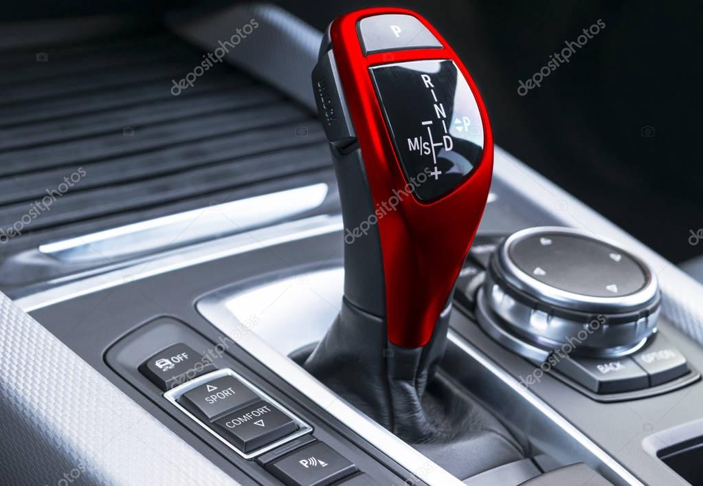  Red Automatic gear stick of a modern car, car interior details, close up