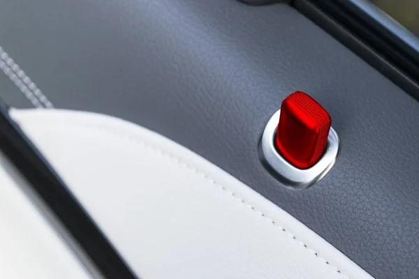 Deurklink met rode sluis bedieningsknoppen voor een luxe personenauto's. Zwarte lederen interieur van de luxe moderne auto. Moderne auto interieur details — Stockfoto