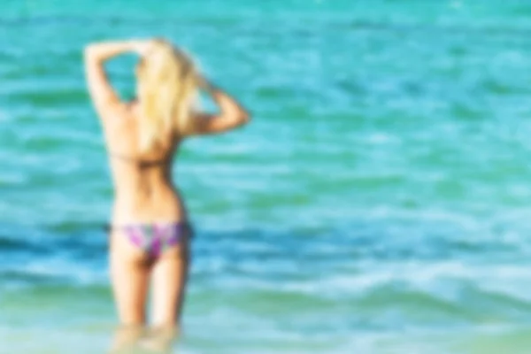 Wazig Sexy achterzijde een mooie vrouw op tropisch strand in kleine sexy bikini. Vervagen van de Oceaan — Stockfoto