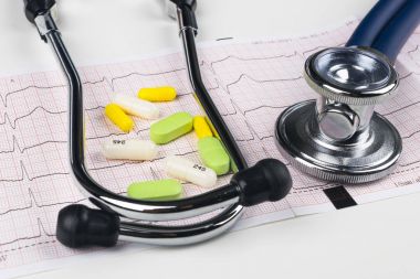 Sağlık stetoskop kardiyogram grafik üzerinde hapları yığını ile yalan. Kardiyoloji bakım sağlık koruma önleme ve yardım. Sağlıklı yaşam ya da sigorta kavramı. EKG, EKG, stetoskop ve farklı hapları.