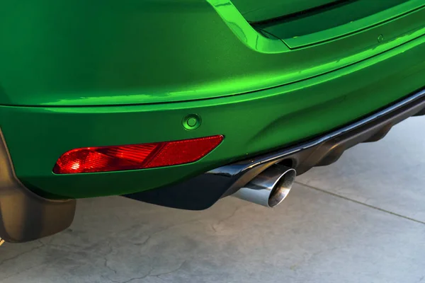 Задній бампер зеленого автомобіля з вихлопною трубою, сучасні зовнішні деталі автомобіля — стокове фото