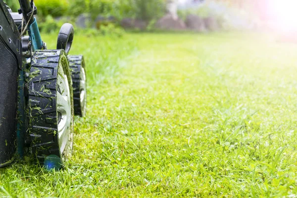 Mowing lawns, Lawn mower on green grass, mower grass equipment, mowing gardener care work tool, close up view, sunny day. Soft lighting — Stock Photo, Image