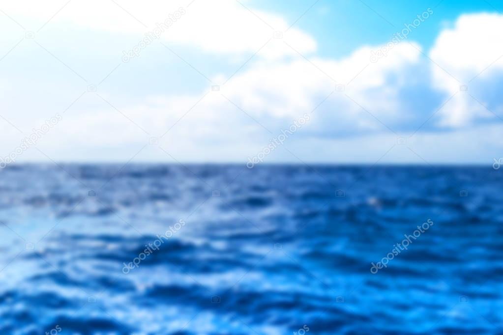 Blurred background with horizon line with summer sky and blur blue ocean