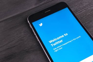 iPhone 7 artı ahşap masa açık Twitter uygulama Twitter üzerinde bir online sosyal ağ ve microblogging hizmet olduğunu. Twitter sosyal mikroblog ağı Twitter Inc tarafından çalıştırılır.