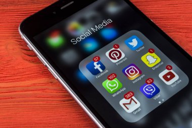 Apple iphone 7 artı ile kutsal kişilerin resmi sosyal medya facebook, instagram, heyecan, snapchat uygulama ekranda kırmızı ahşap masa. Başlangıç sosyal medya uygulaması.