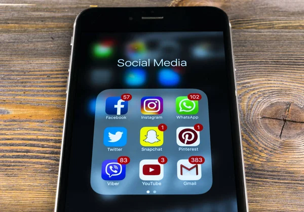 Apple iphone 7 na drewnianym stole z ikonami z mediów społecznościowych facebook, twitter, instagram, snapchat aplikacji na ekranie. Smartphone rozpoczęcie aplikacji mediów społecznościowych. — Zdjęcie stockowe