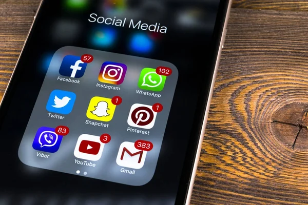Apple iphone 7 na drewnianym stole z ikonami z mediów społecznościowych facebook, twitter, instagram, snapchat aplikacji na ekranie. Smartphone rozpoczęcie aplikacji mediów społecznościowych. — Zdjęcie stockowe