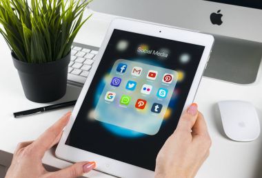 Sosyal medya facebook, instagram, heyecan, google uygulama ekran simgeleri ile iPad pro kullanarak kadın eller. Smartphone başlamak sosyal medya uygulaması.