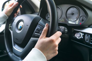 Kadının bir Bmw X 5 F15 sürüş direksiyon eller. Direksiyon simidi holding eller. Modern araba iç detaylar.