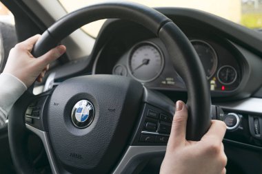 Kadının bir Bmw X 5 F15 sürüş direksiyon eller. Direksiyon simidi holding eller. Modern araba iç detaylar.